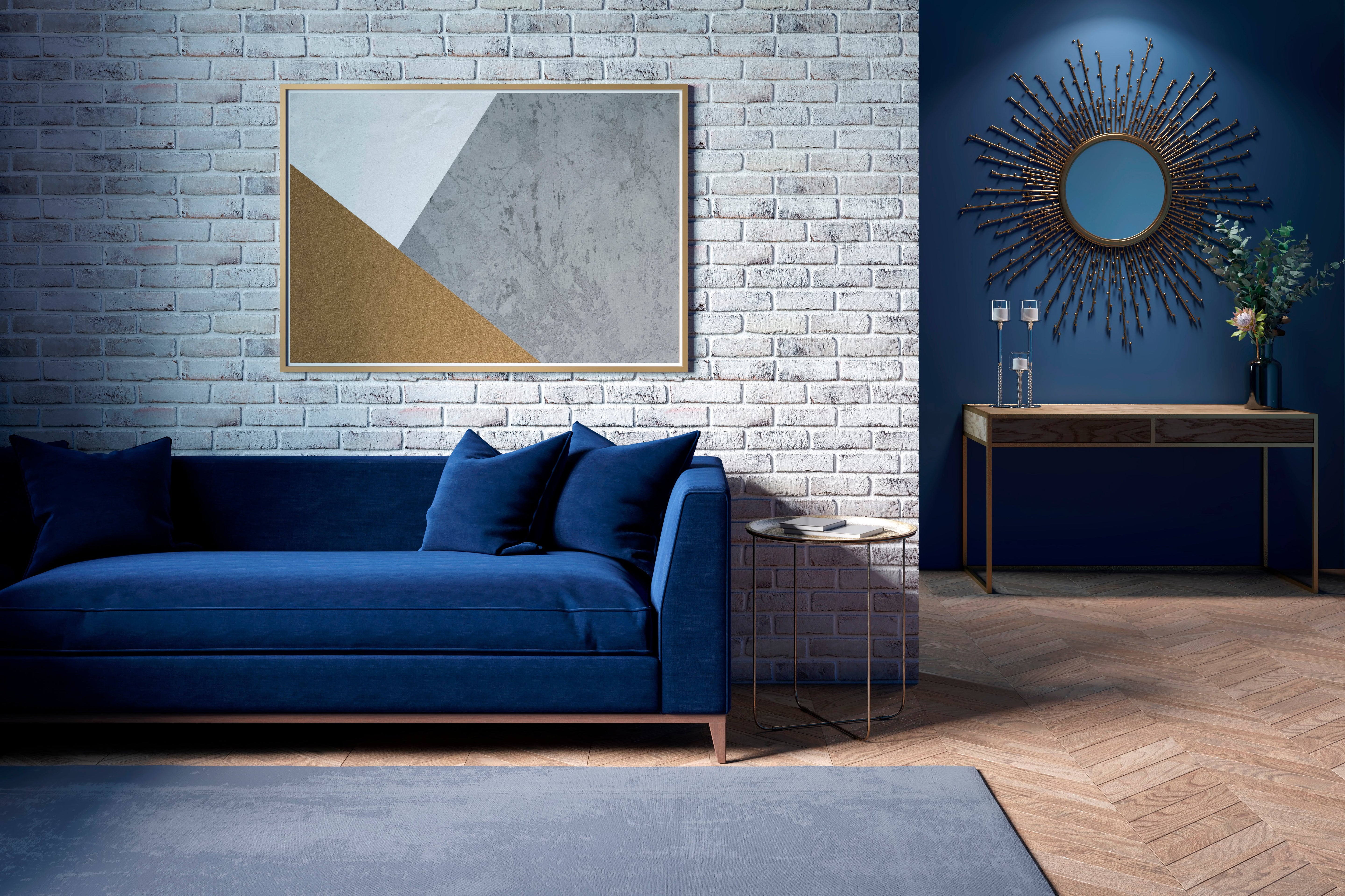 Modern living room with blue velvet sofa, geometric wall art, and sunburst mirror against brick and navy walls, showcasing chic decor.