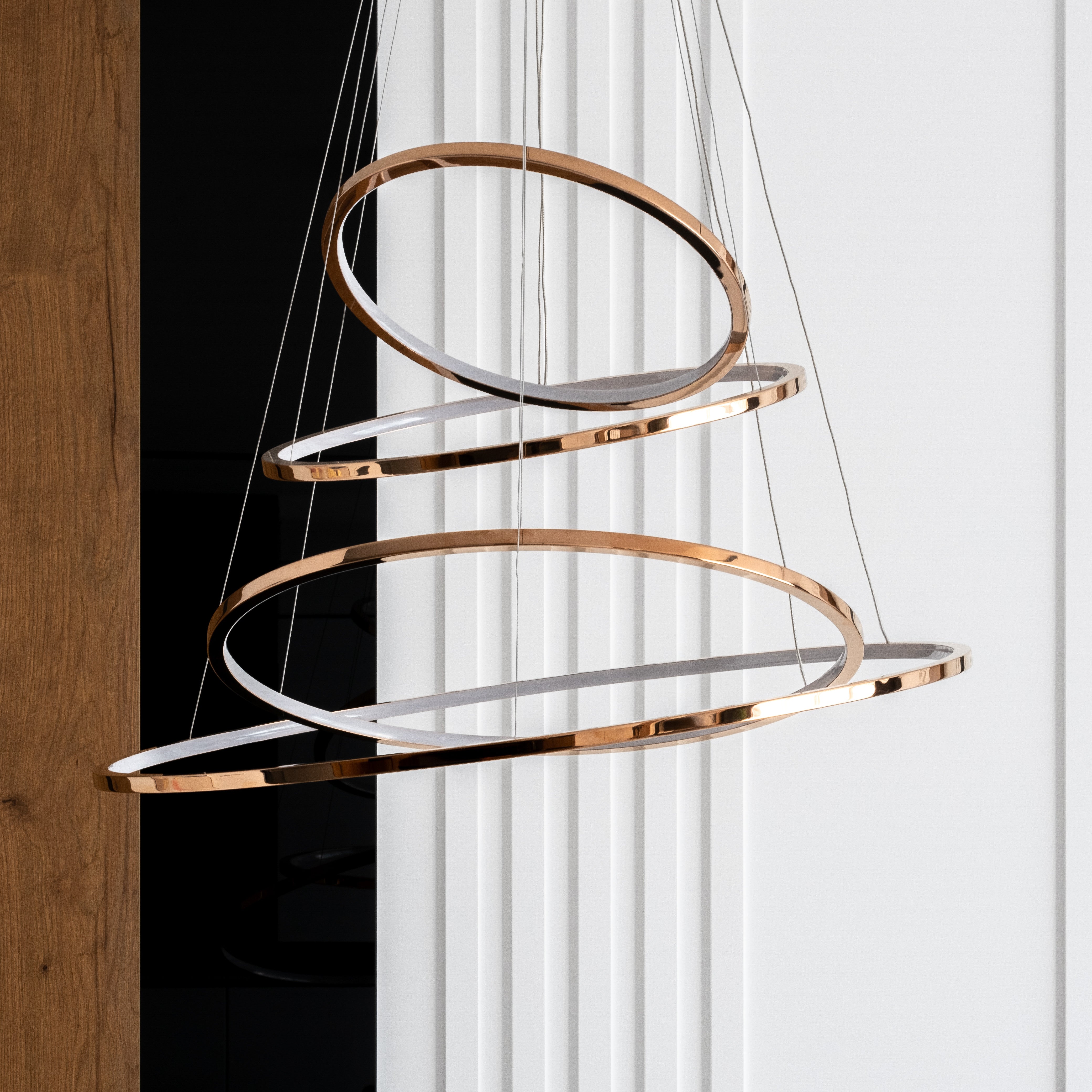 Modern gold and silver ring chandelier hanging against a white background