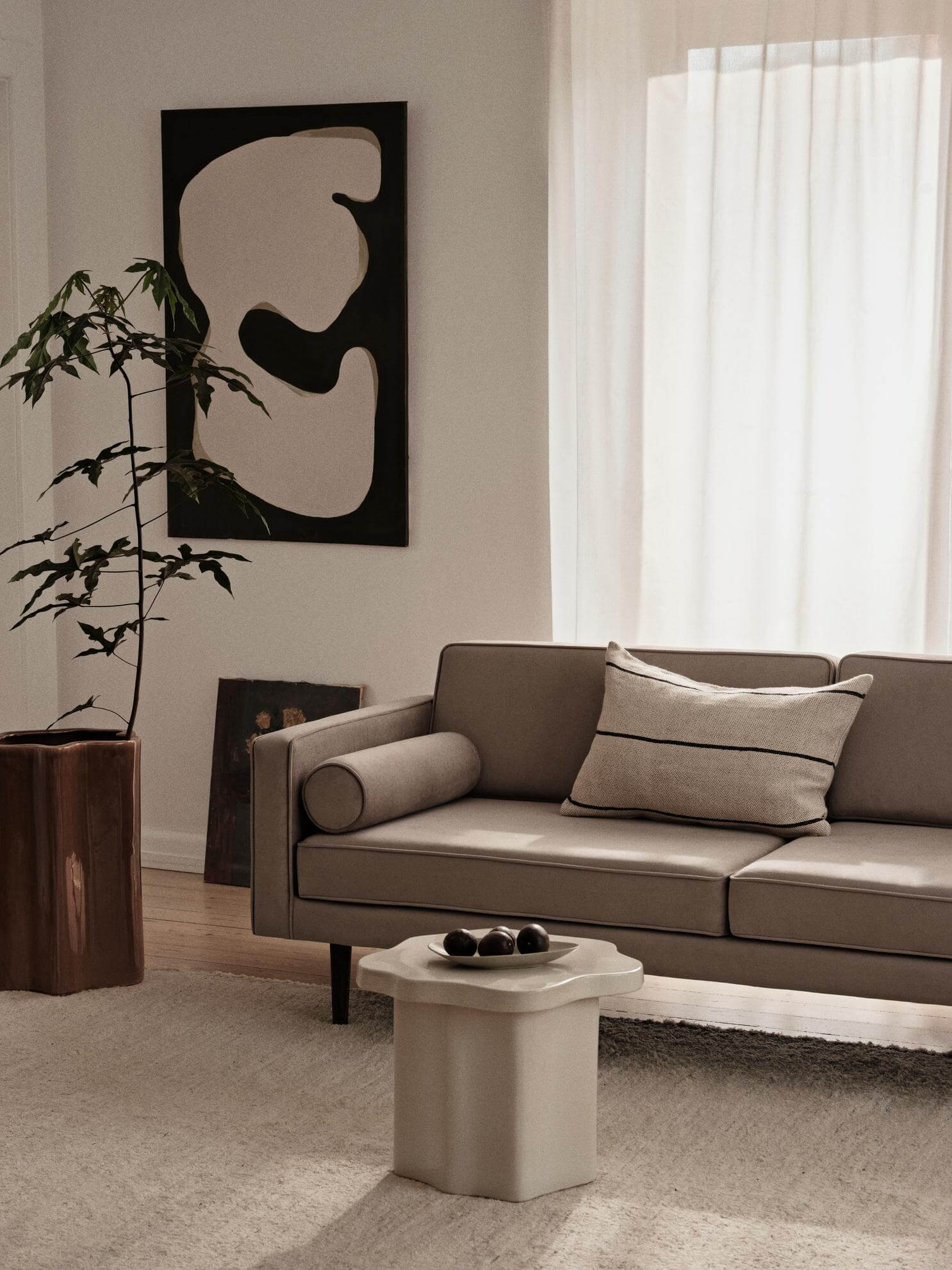 Modern living room with designer sofa, abstract art, and minimalist decor, showcasing luxury furniture for premium home furnishings.