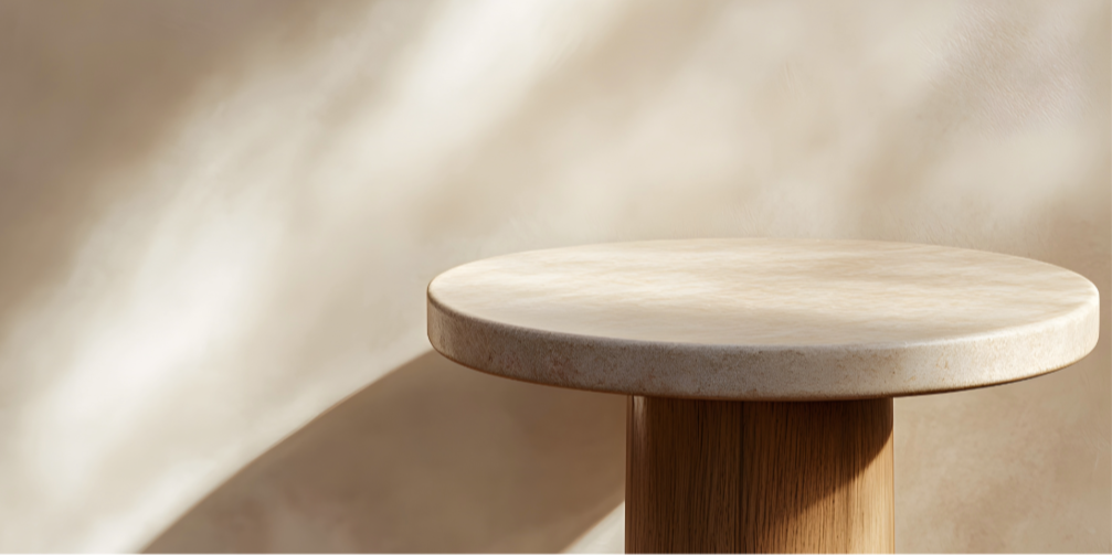 Minimalist round wooden table in soft natural light, neutral tones with gentle shadows, ideal for elegant interior design inspiration.
