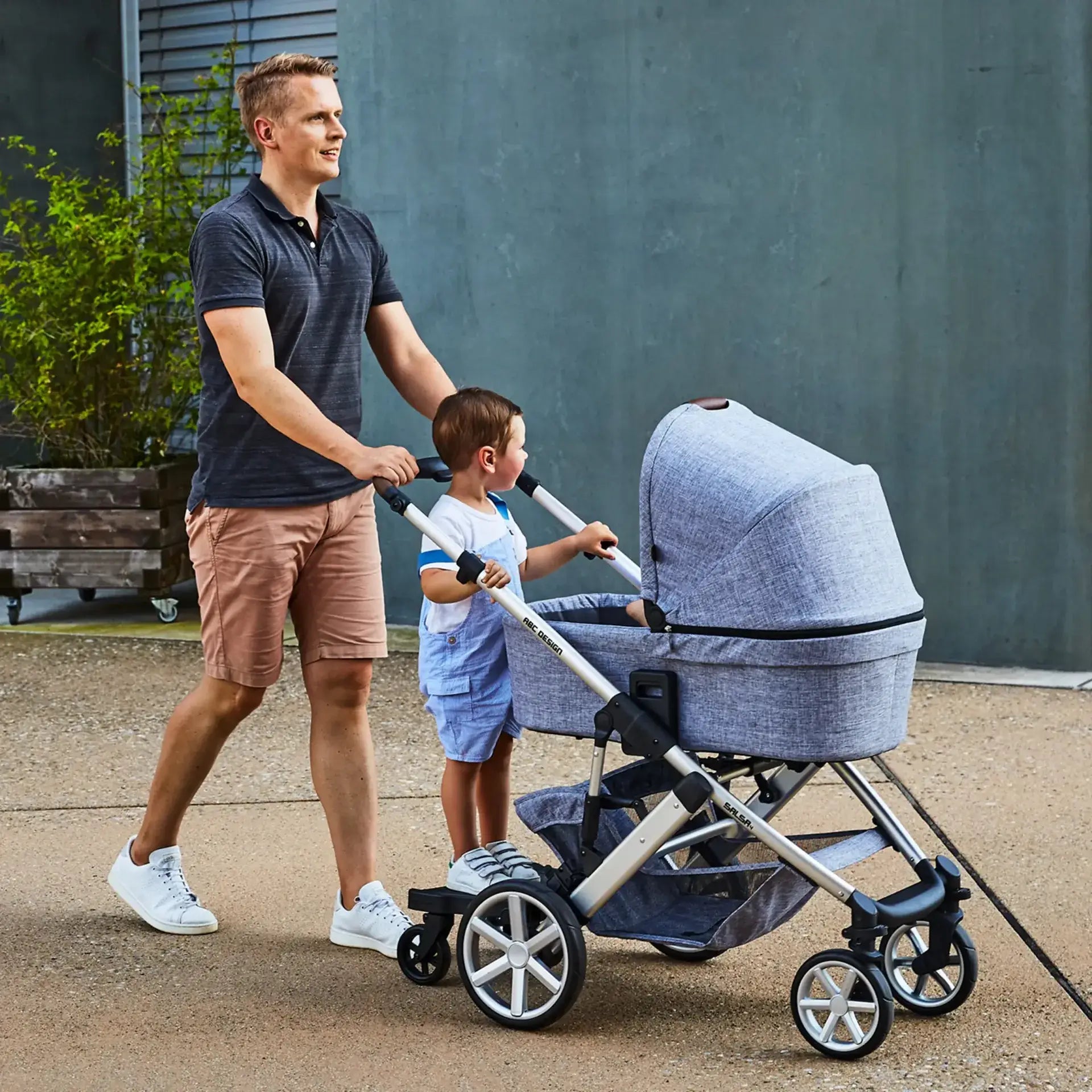 Father and child enjoying a smooth ride on the ABC Design Kiddie Ride On 2 Board, luxury modern furniture for strollers.