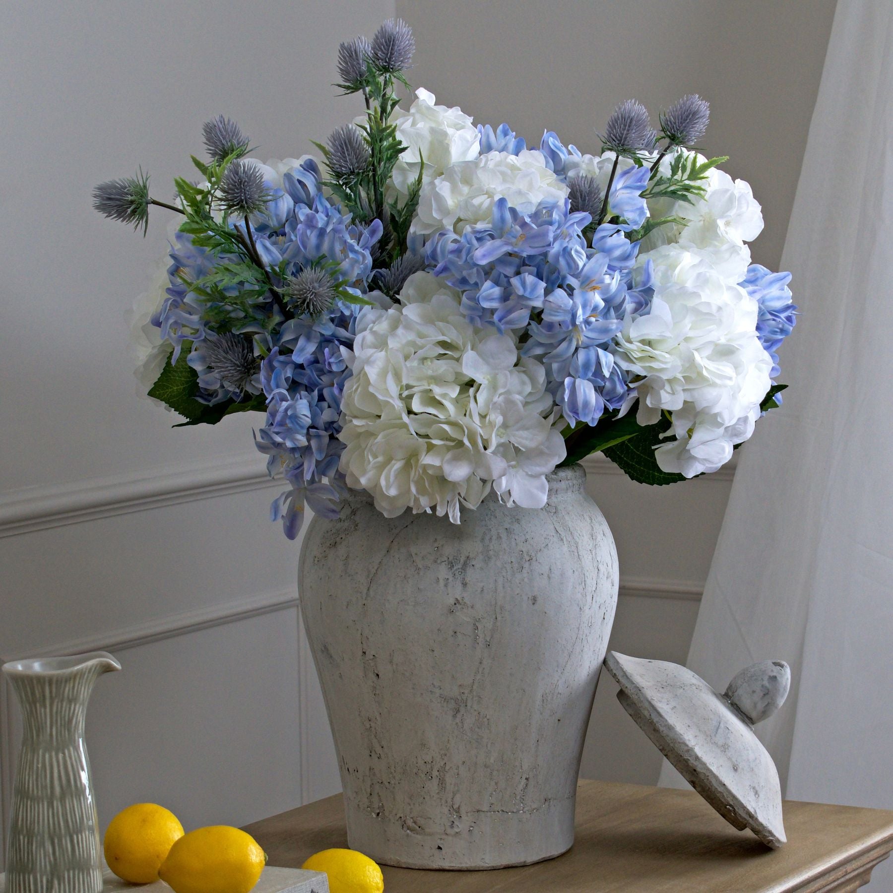 Bloomville Stone Ginger Jar with vibrant blue and white floral arrangement. Luxury and designer furniture by top vendor. Premium home decor.
