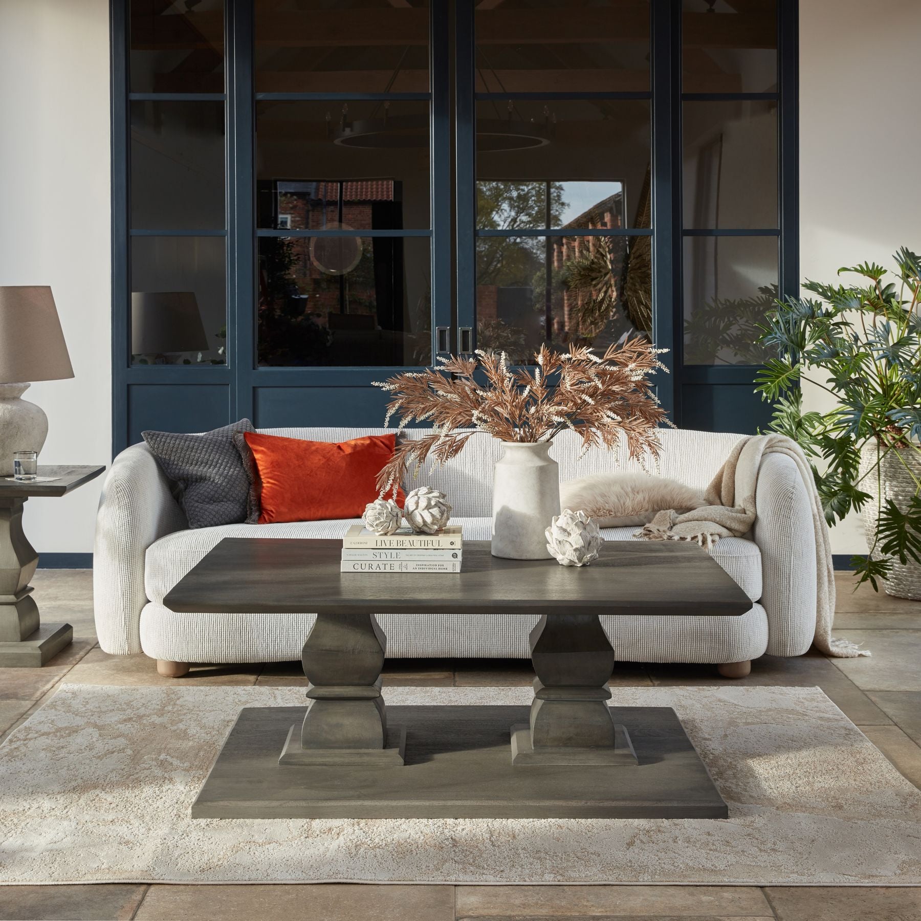 Modern living room with luxury furniture, featuring a chic white sofa, designer coffee table, and curated decor for premium home aesthetics.