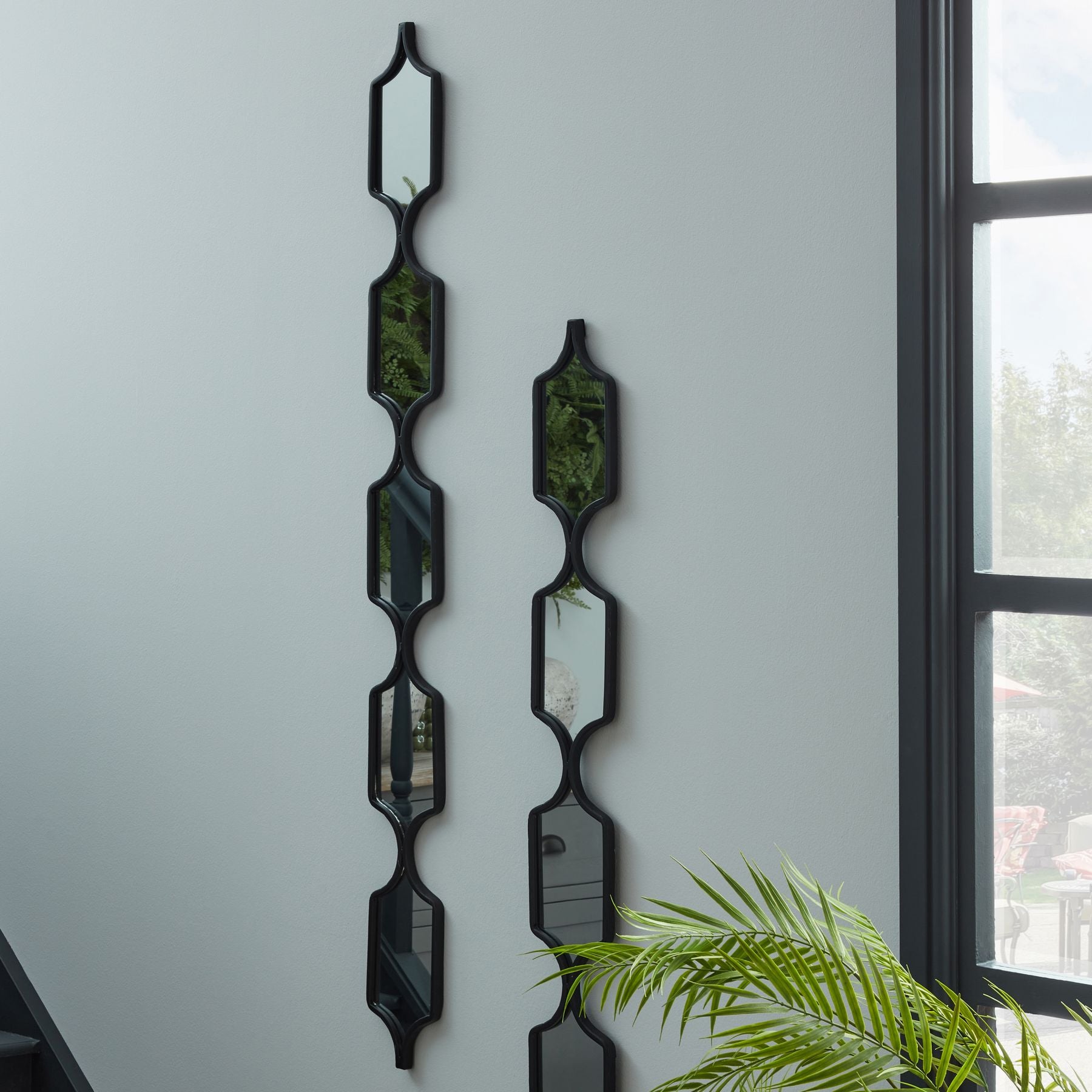 Decorative modern black hanging mirror with minimalist metal frame and geometric design, ideal for luxury and designer home decor.