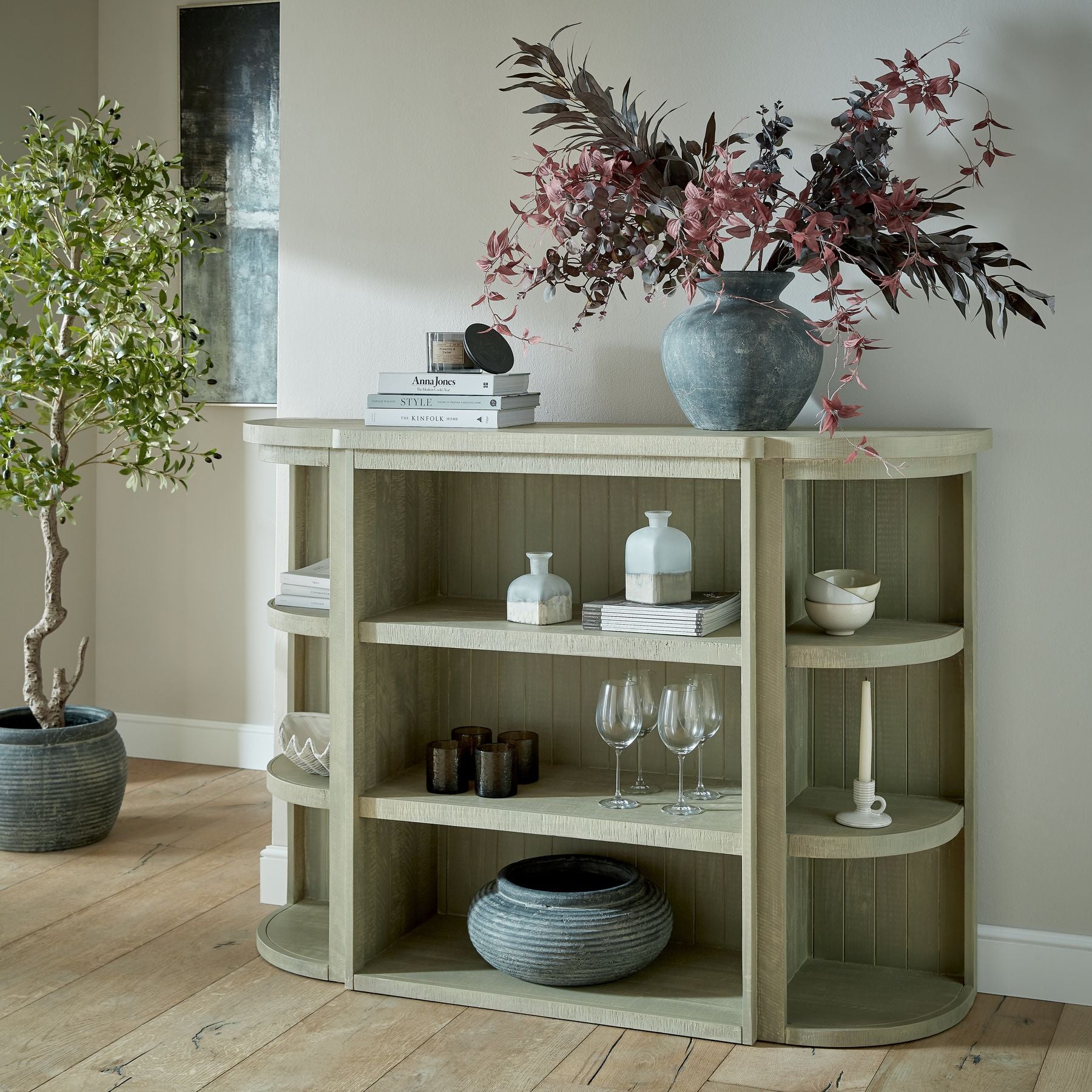 Amalfi Grey Vase on modern shelf with decor books, wine glasses, and plants. Luxury and designer furniture. Premium home furnishings.