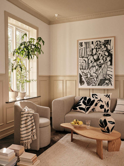 Alt Tag: Cozy modern living room featuring a Pond Armchair with soft latte upholstery, blending elegance with contemporary design.
