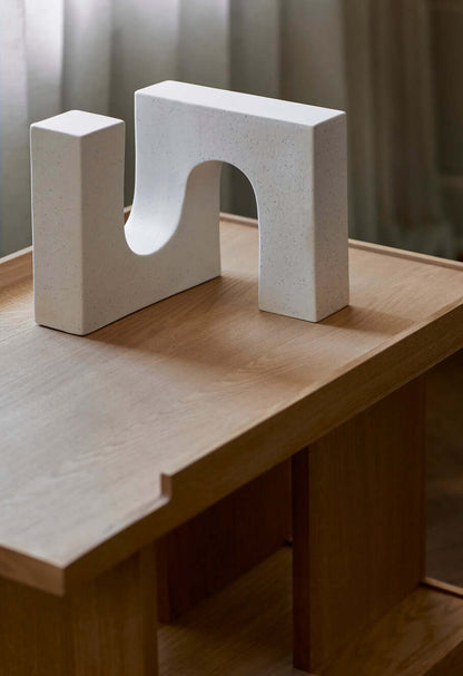 Modern white sculpture on wooden table, showcasing luxury and designer furniture aesthetic for high-end home decor.