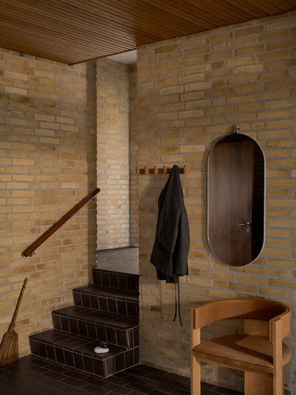 Collector Dining Chair in leather against a brick wall, showcasing luxury and designer furniture aesthetics for premium home decor.