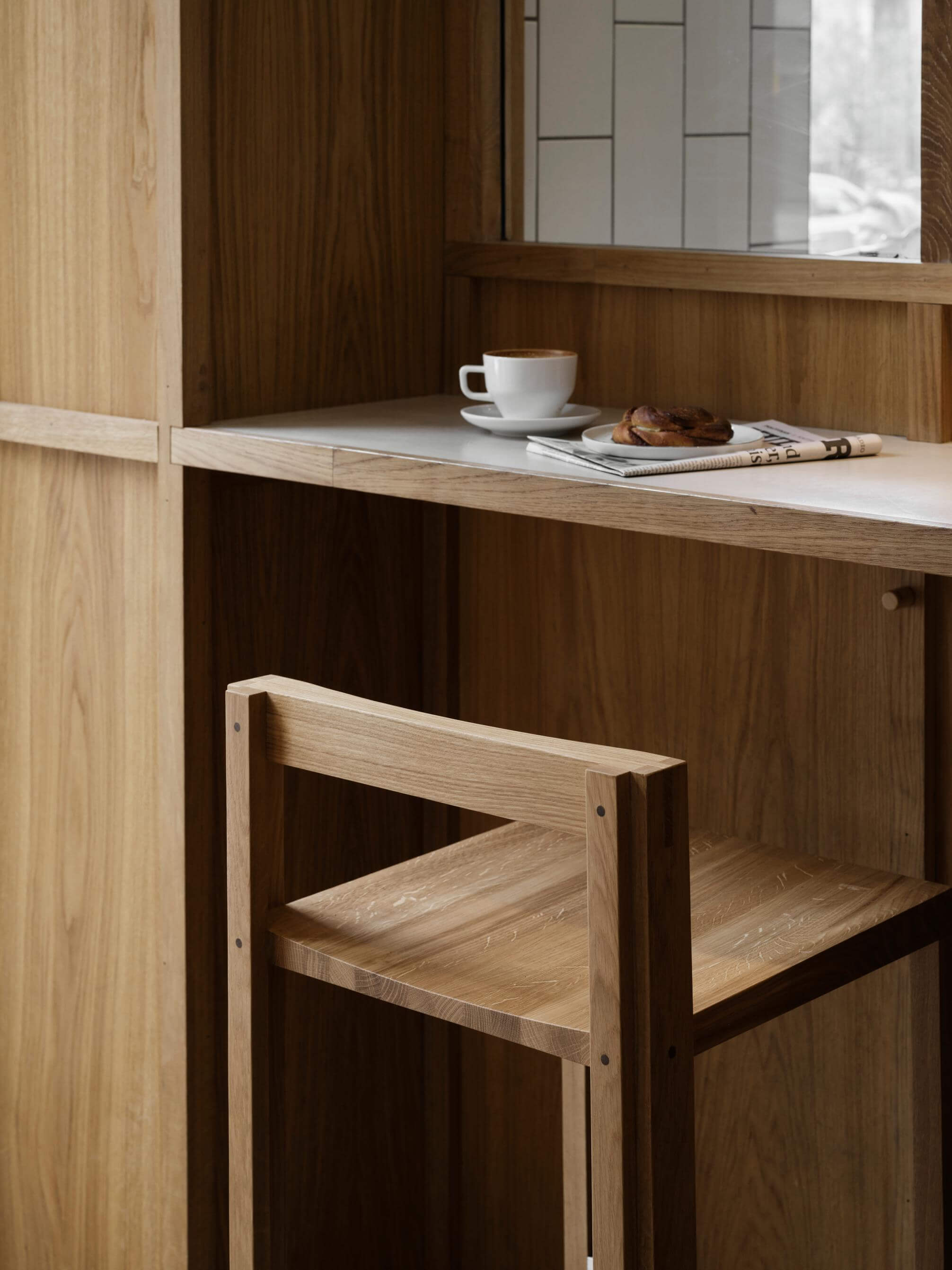 Outline Bar Chair High in oak at a kitchen island, showcasing luxury and modern design. Part of curated premium home furnishings collection.