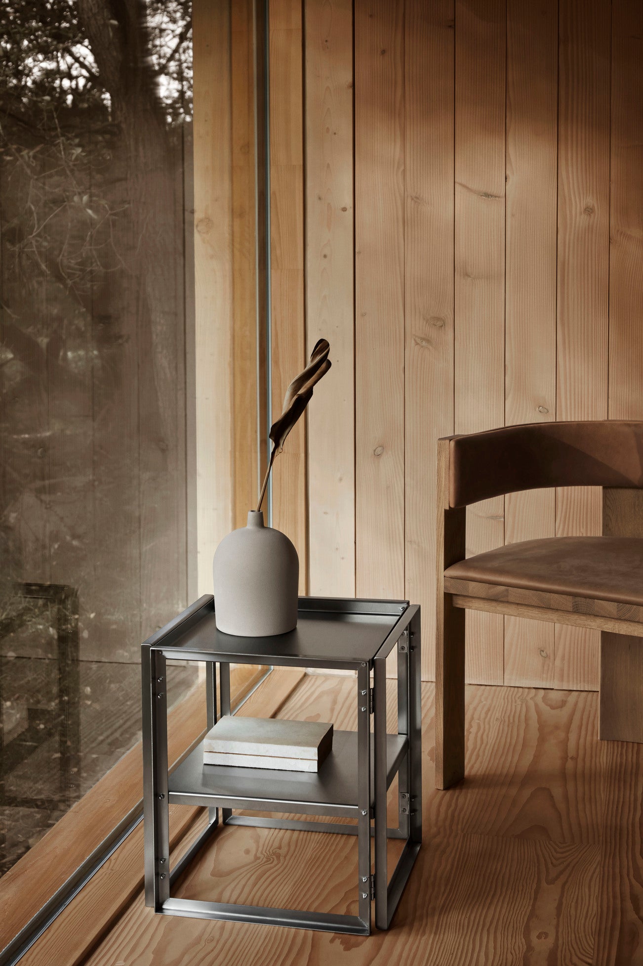 Luxury and modern living room corner with wooden chair and metal side table. Premium home furnishings perfect for curated furniture collections.