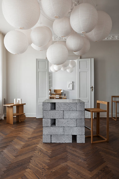 Modern interior with geometric Axis Side Table, showcasing luxury designer furniture in a minimalist setting with floating white lanterns.