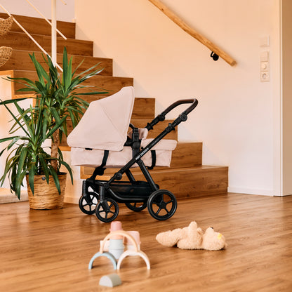 Modern baby stroller in a stylish living space with natural wood floors and stairs, surrounded by cozy decor and greenery.
